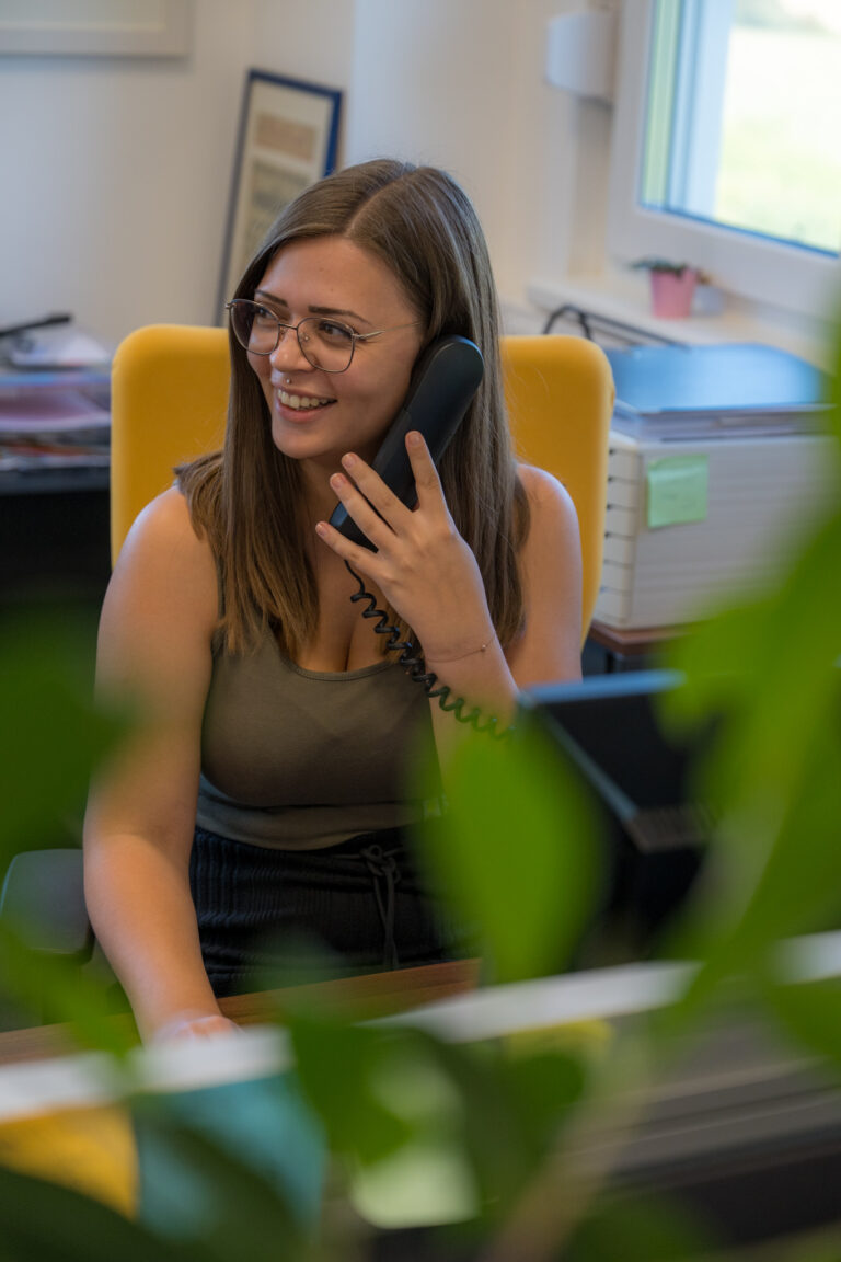 Frau an einem Schreibtisch telefoniert